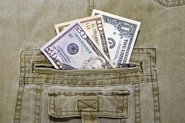 US currency dollar notes in pocket of khaki trousers
