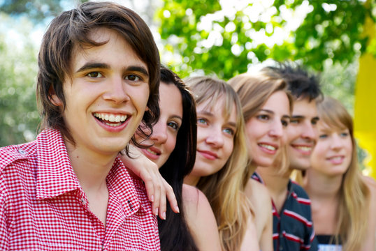 Portrait of a beautiful young guy and friends group