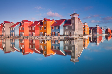 Colorful wooden houses near water - obrazy, fototapety, plakaty