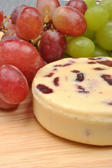 cheese and some sweet grapes in the background