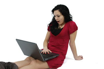 happy young girl looking shocked at a laptop isolated