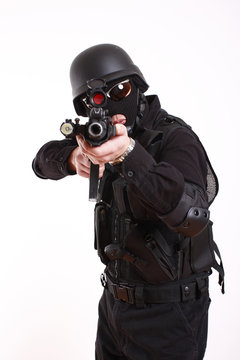 SWAT police officer aiming assault gun.