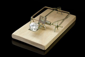 A large solitaire diamond in a loaded mousetrap