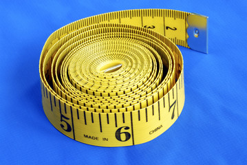 A coiled-like measuring tape isolated on blue background