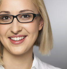young woman wearing glasses, smiling