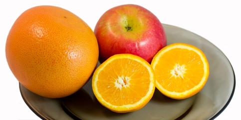 Grapefruit, apple and half of orange on a plate