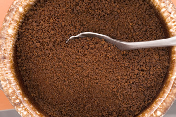 Spoon in dry coffee grounds.
