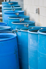 Blue rain barrels in a row flowing into each other