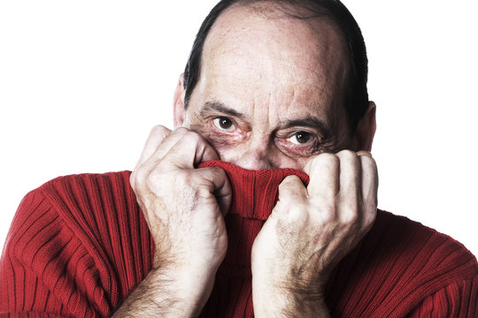 homme ag&eacute; cach&eacute; dans son pull rouge