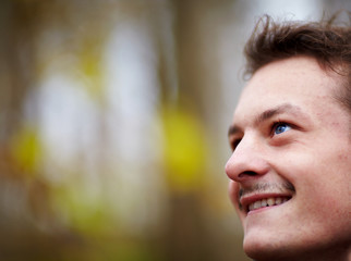 Happy young man looking up at copy space