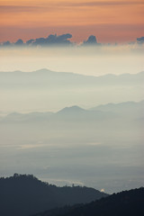 Obraz premium Foggy morning sunrise with high mountain background