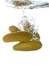 Pickles falling into clear water