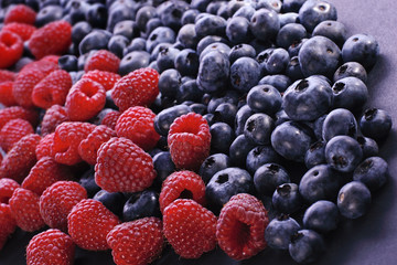 Raspberry and bilberries on the white background