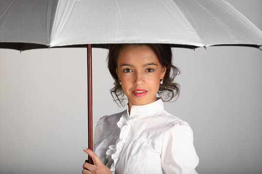 Beautiful woman portrait with umbrella on white