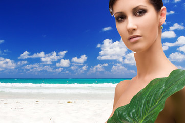 Fototapeta na wymiar woman with green leaf on tropical beach