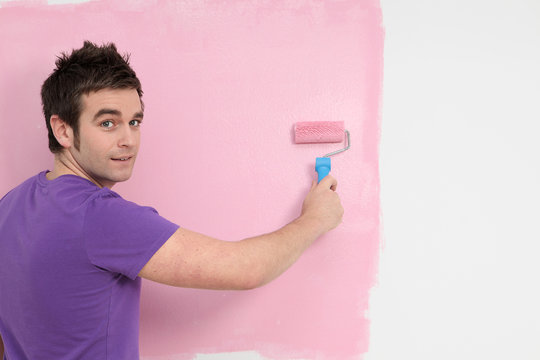 man painting wall, decorating new home
