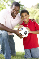 Father And Son In Park With Football