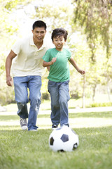 Father And Son In Park With Football