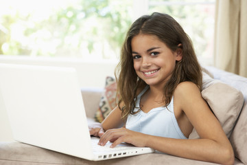 Young Girl Using Laptop At Home