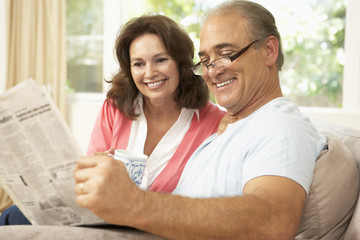 Senior Couple Reading Newspaper At Home