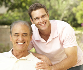 Obraz premium Senior Man Hugging Adult Son