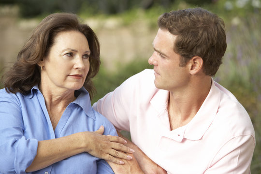 Senior Woman Being Comforted By Adult Son