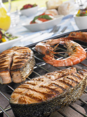 Salmon And Prawns Cooking On A Grill