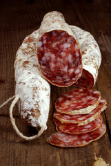 Two salami on a wooden board with slices