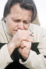 colour portrait of depressed man smoking cigarette