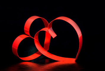 St. Valentine Day.Two red hearts, on black, with reflection