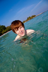 Junge im klaren Wasser geniesst das Meer