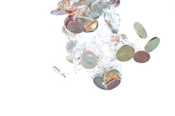 Euro coins falling into the clear water