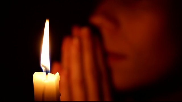 girl praying by candlelight