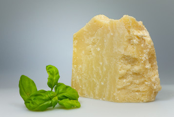 Parmesanstück mit Basilikumblatt