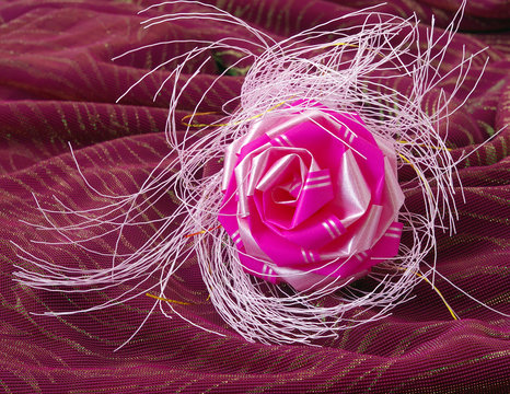 Decorative rose on wine-colored fabrics (still-life)