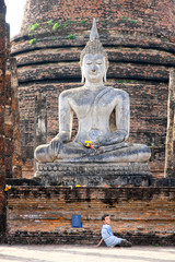 Young chilren under Buddha Statue,  Sukhothai, Thailand,