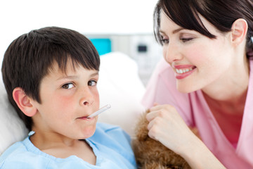 Charming nurse taking little boy's temperature
