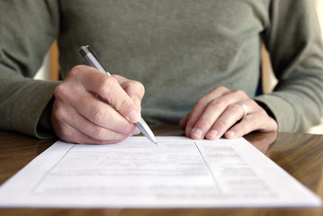 Man Writing on Paper with Pen on Table - obrazy, fototapety, plakaty