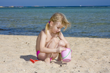 A child playing in the sand of the sea