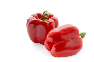 Two red sweet peppers on a white background