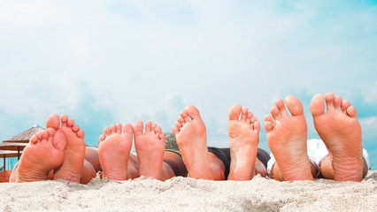 Young couples feet at the beach - obrazy, fototapety, plakaty