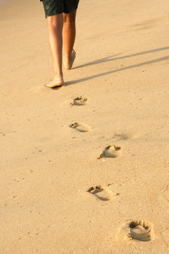A boy walking along the beach