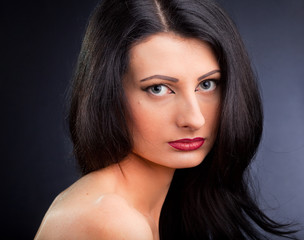 Obraz premium Beautiful young woman face over dark background
