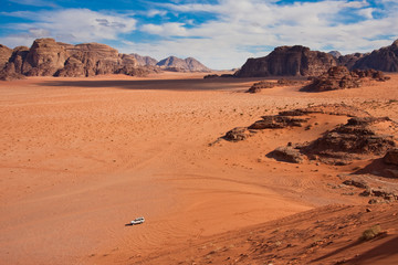 Fototapeta na wymiar White jeep in a Wadi Rum desert, Jordan.