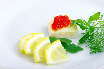 Sandwiches with red caviar and greens on a white plate