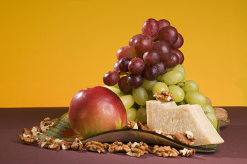 Fruits and cheese lying on a plate.