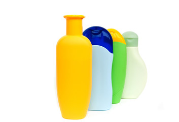 four colured shampoo bottles isolated on white