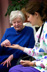 Nurse giving senior woman a bottle of pills