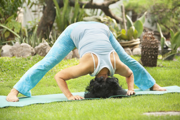Senior old woman doing yoga in park