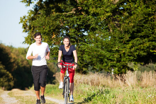 Young sport couple jogging and cycling